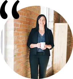 Elinde bir fincan kahve tutan bir kadının yakın plan portresi; odak noktası gözler ve sıcak atmosfer.